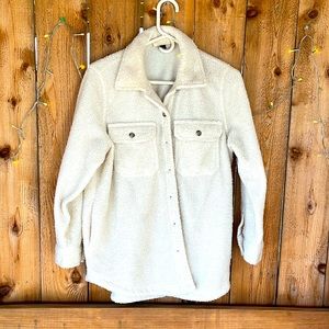 Women’s oversized, button-down lapel shirt with pockets. Cream